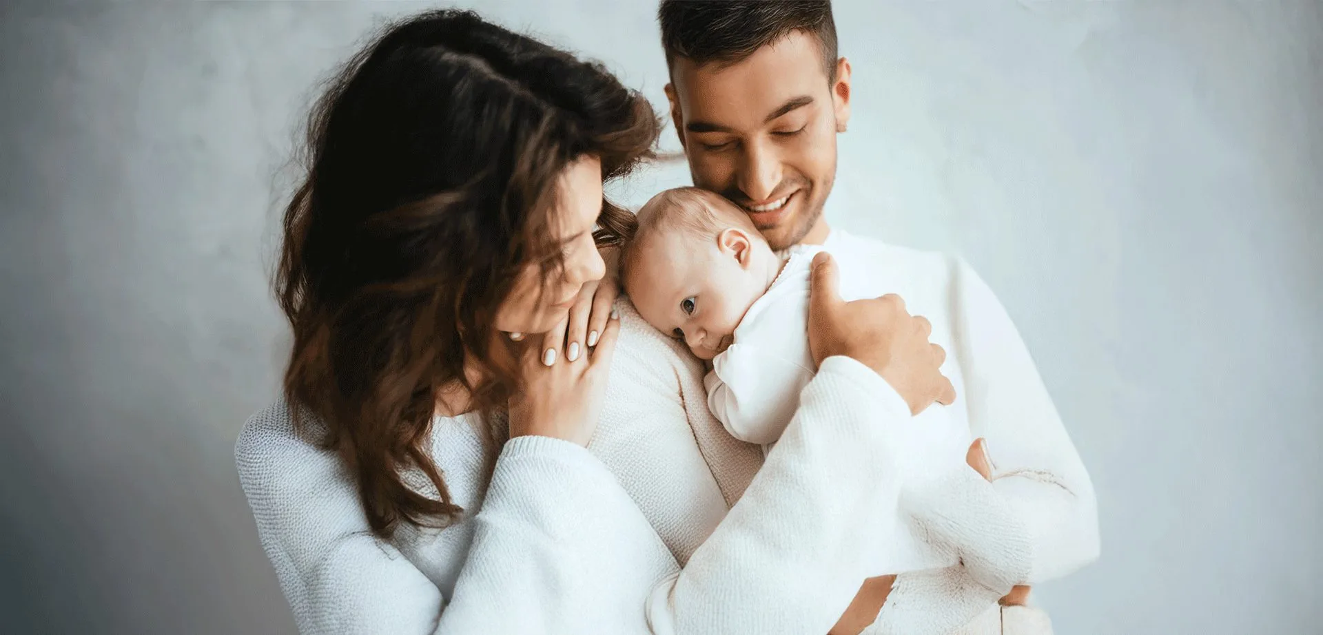 mom and father holding their baby boy smiling
